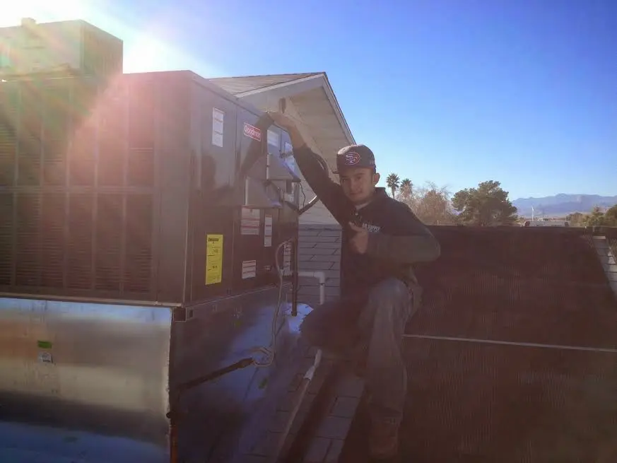 HVAC technician performing HVAC Inspection on a rooftop unit in Aubrey